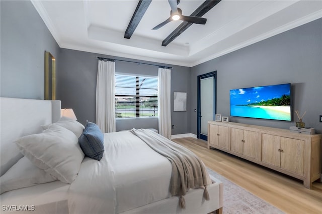 bedroom featuring ceiling fan, a raised ceiling, ornamental molding, and light wood-type flooring