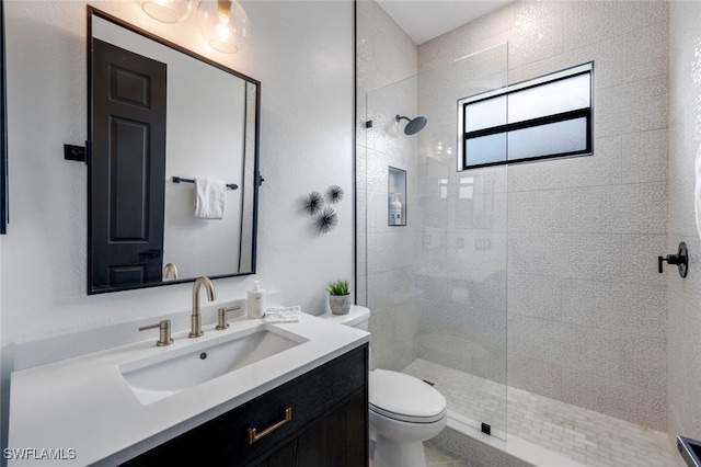 bathroom featuring toilet, an enclosed shower, and vanity