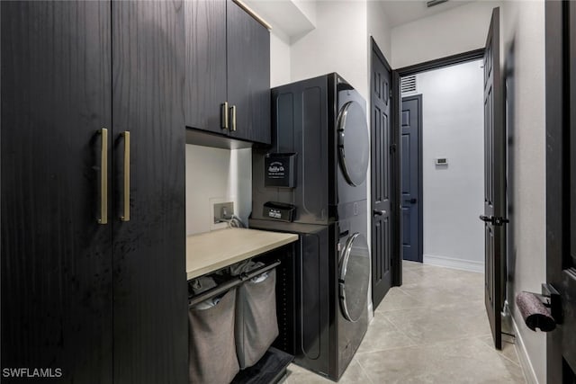 kitchen featuring stacked washer and clothes dryer and light tile patterned floors