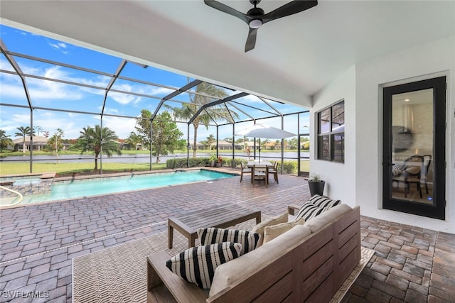 view of swimming pool featuring a patio, ceiling fan, and glass enclosure