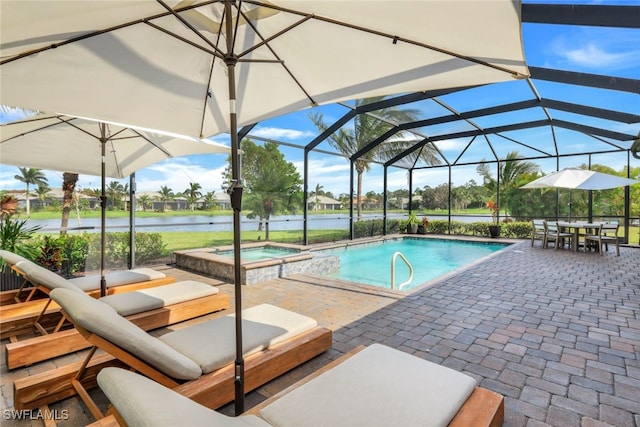 view of swimming pool featuring an in ground hot tub, a patio area, glass enclosure, and a water view