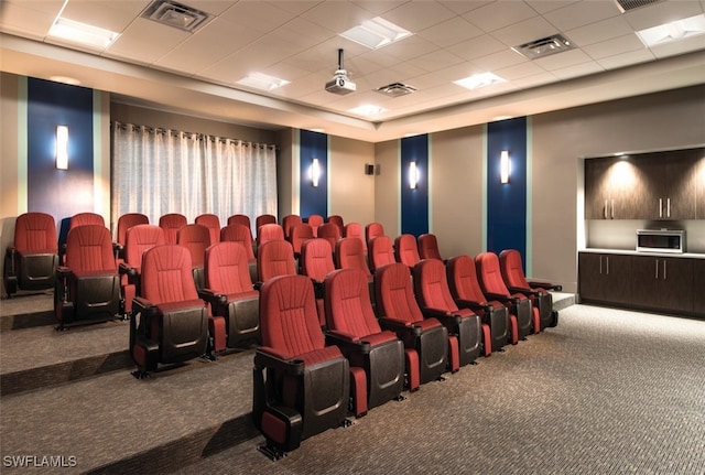 carpeted cinema featuring a drop ceiling