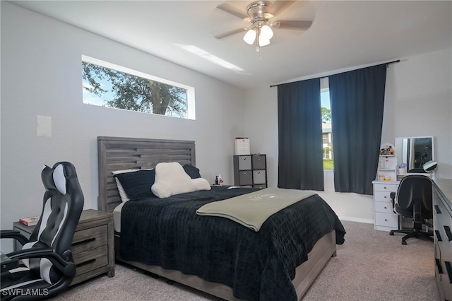 carpeted bedroom featuring ceiling fan and multiple windows