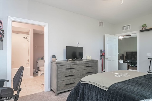 bedroom featuring light colored carpet and ensuite bath