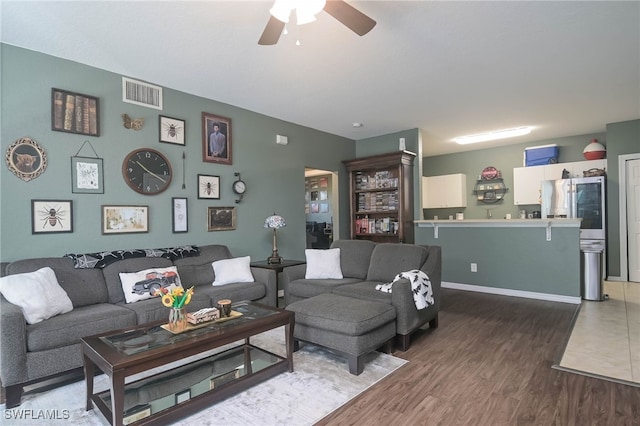 living room with ceiling fan and dark hardwood / wood-style flooring