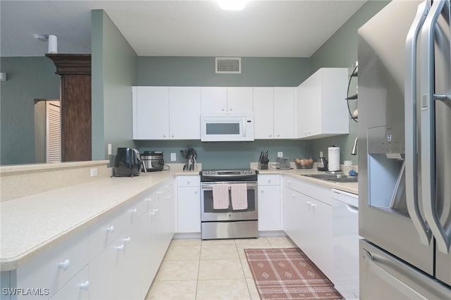 kitchen featuring white cabinetry, white appliances, and light tile patterned floors