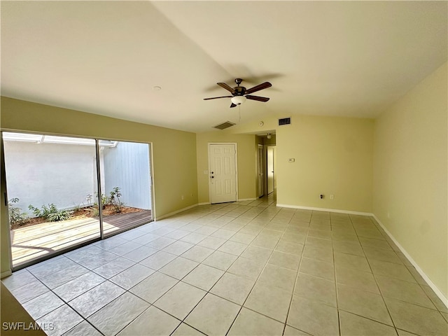 empty room featuring lofted ceiling, light tile patterned floors, and ceiling fan