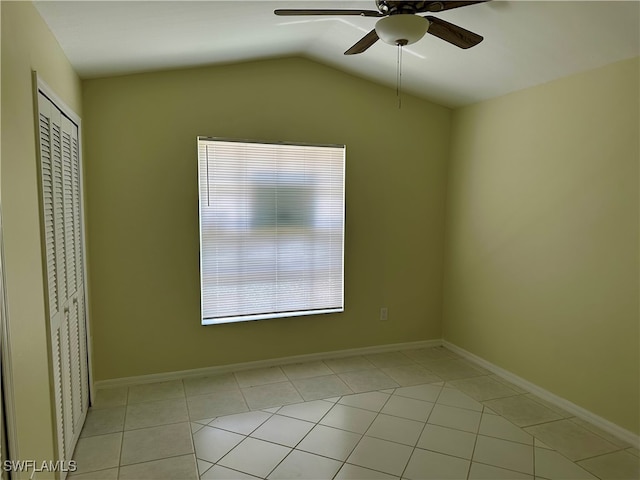 unfurnished room featuring lofted ceiling, ceiling fan, and light tile patterned floors