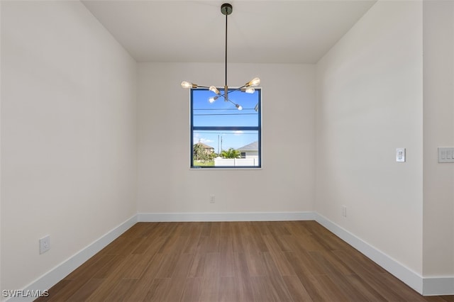 unfurnished dining area featuring dark hardwood / wood-style flooring and an inviting chandelier