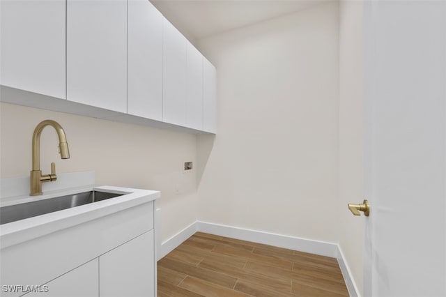 laundry room with cabinets, hookup for a washing machine, and sink