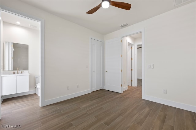 unfurnished bedroom featuring connected bathroom, ceiling fan, and sink