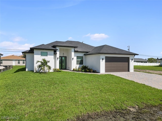 prairie-style home with a front lawn and a garage