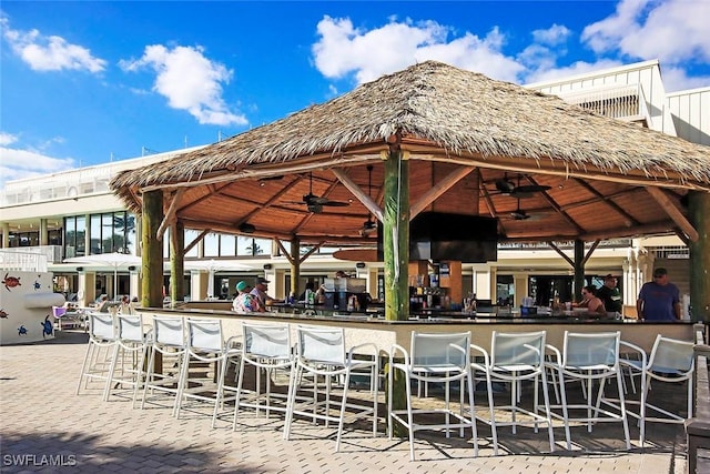 view of patio / terrace featuring a gazebo, ceiling fan, and a bar