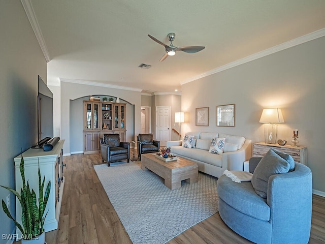 living room with ceiling fan, ornamental molding, and hardwood / wood-style flooring