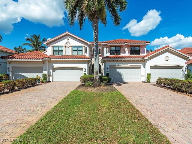 mediterranean / spanish-style home with a garage and a front yard