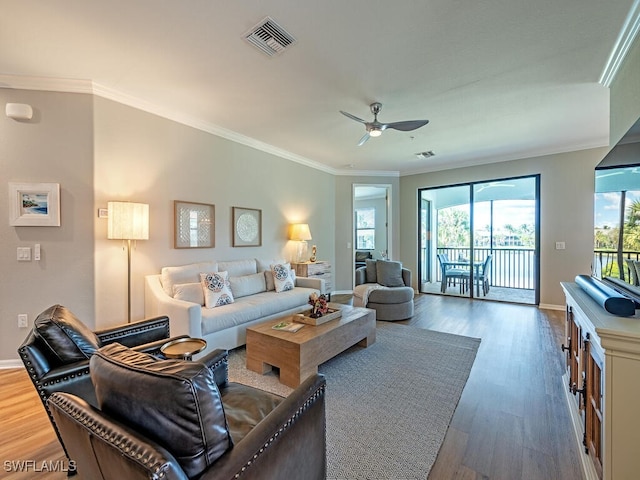 living room with dark hardwood / wood-style floors, ceiling fan, and crown molding