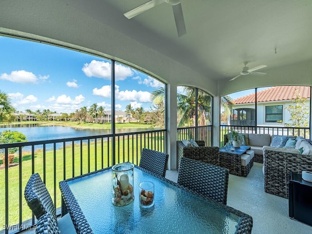 sunroom featuring a water view and ceiling fan