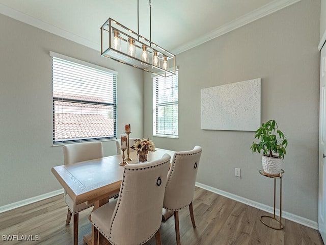 dining room with hardwood / wood-style floors, plenty of natural light, and crown molding