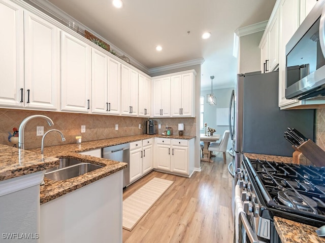 kitchen with white cabinets, backsplash, stainless steel appliances, and crown molding