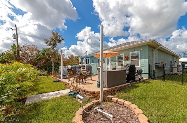 rear view of house featuring a patio area and a lawn