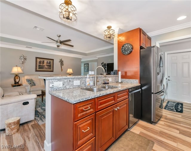 kitchen with light stone countertops, kitchen peninsula, stainless steel appliances, and light hardwood / wood-style floors