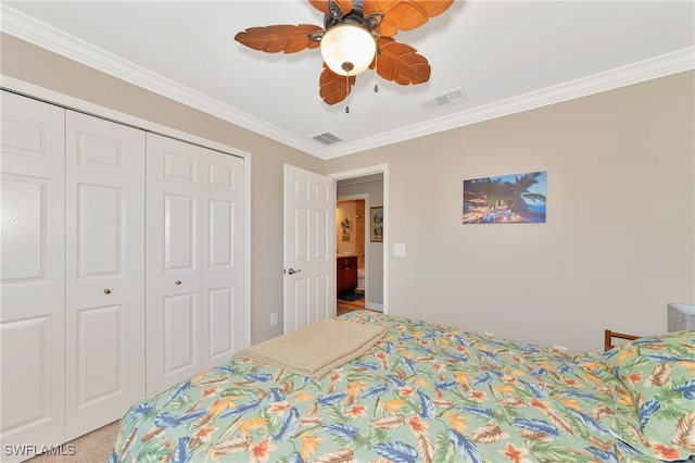 carpeted bedroom featuring crown molding, a closet, and ceiling fan