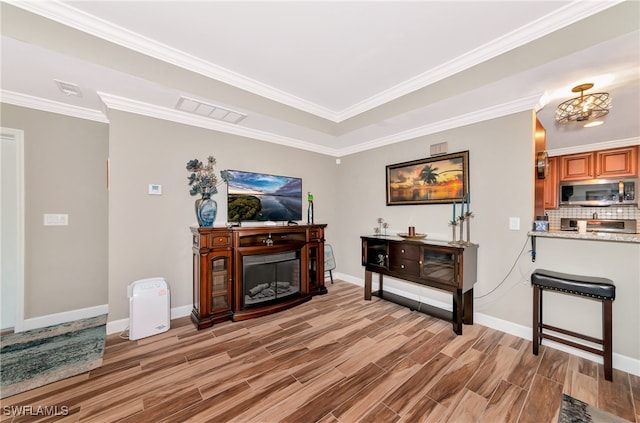 living room with crown molding and light hardwood / wood-style flooring