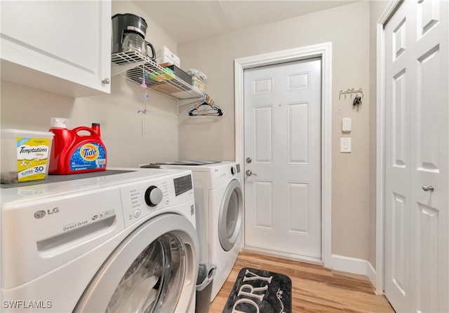 clothes washing area featuring cabinets, light hardwood / wood-style flooring, and washing machine and clothes dryer