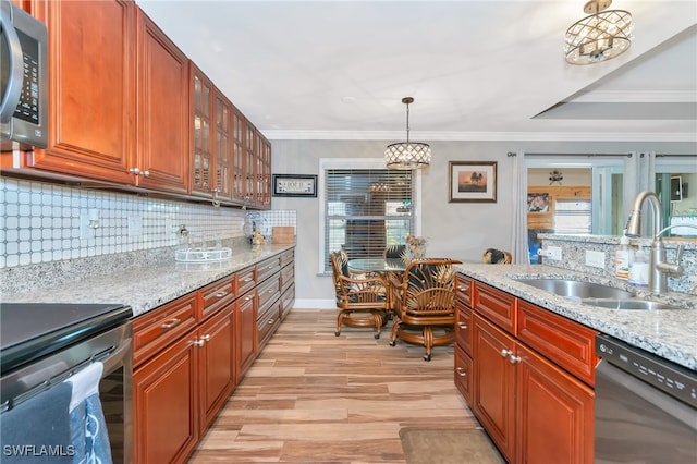 kitchen featuring light hardwood / wood-style flooring, stainless steel appliances, sink, light stone countertops, and decorative light fixtures