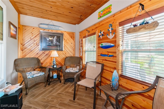 sitting room featuring parquet flooring, wooden walls, and wooden ceiling