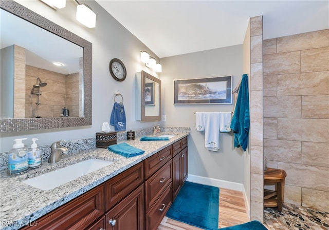 bathroom with vanity, a tile shower, and hardwood / wood-style flooring