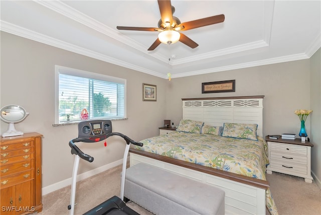 bedroom featuring crown molding, a tray ceiling, carpet, and ceiling fan