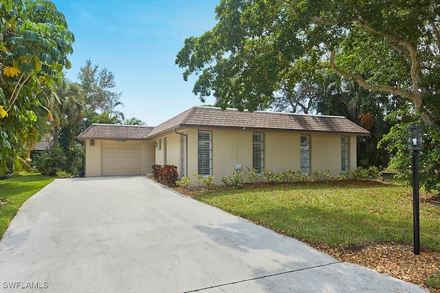 ranch-style home with a front lawn and a garage