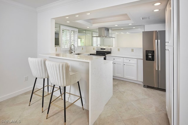 kitchen featuring appliances with stainless steel finishes, kitchen peninsula, white cabinets, a breakfast bar area, and ventilation hood