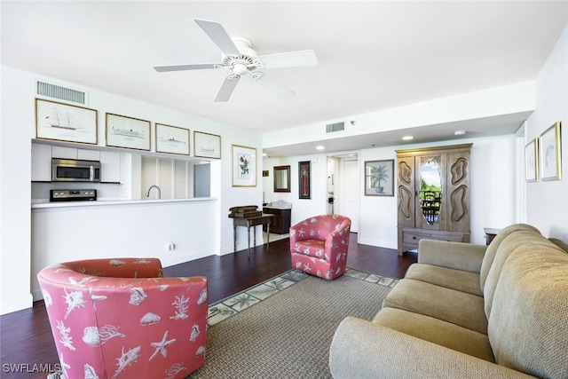 living room featuring ceiling fan, sink, and dark hardwood / wood-style floors