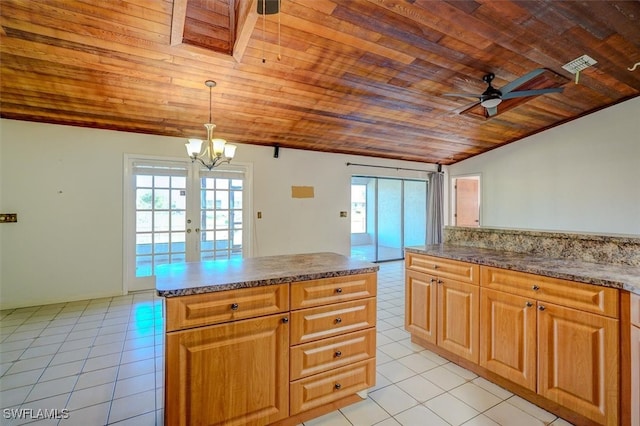 kitchen with light tile patterned floors, a healthy amount of sunlight, wooden ceiling, and decorative light fixtures