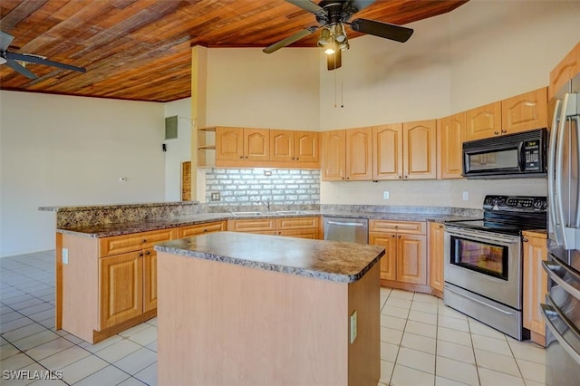 kitchen with stainless steel appliances, light brown cabinetry, sink, and a kitchen island