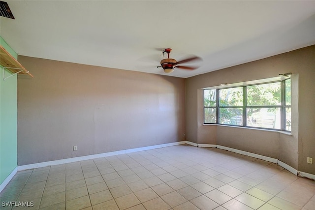 tiled spare room featuring ceiling fan