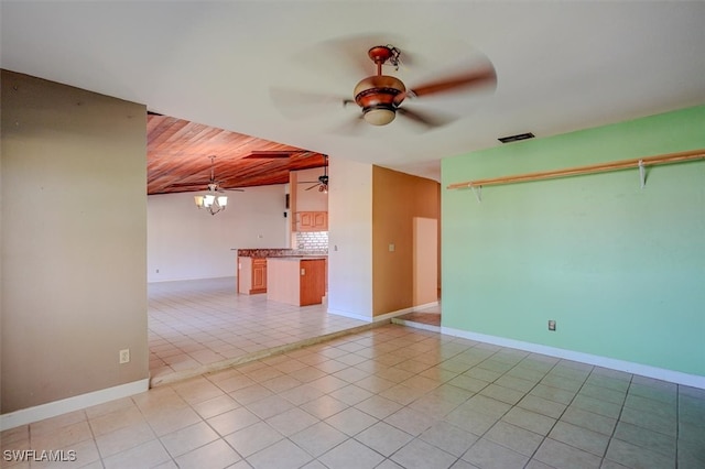 tiled spare room featuring wood ceiling and ceiling fan