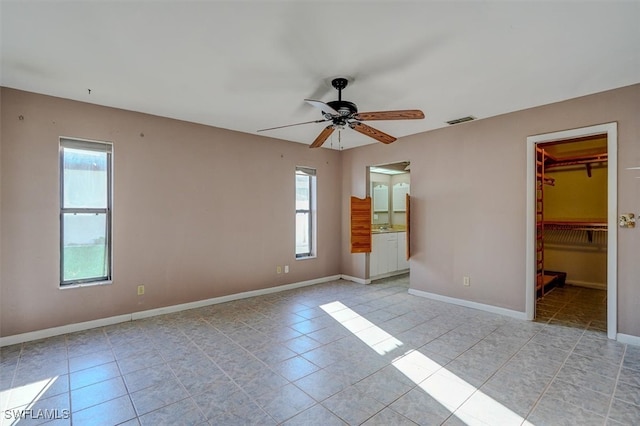 tiled spare room featuring plenty of natural light and ceiling fan