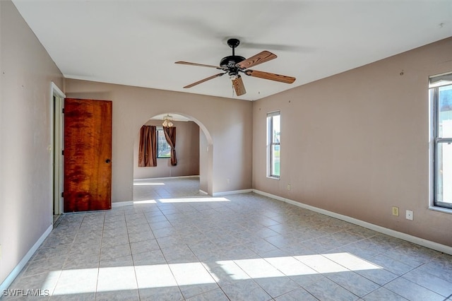 tiled empty room with plenty of natural light and ceiling fan