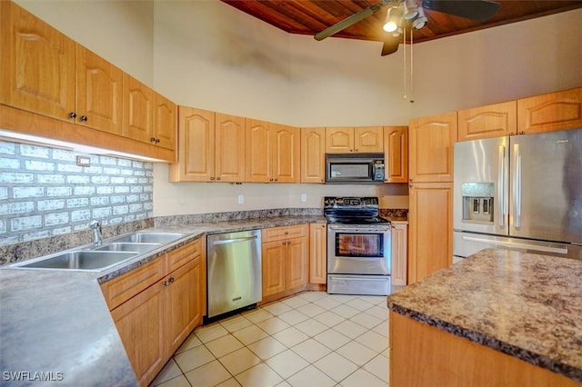 kitchen with a towering ceiling, sink, ceiling fan, stainless steel appliances, and light tile patterned floors