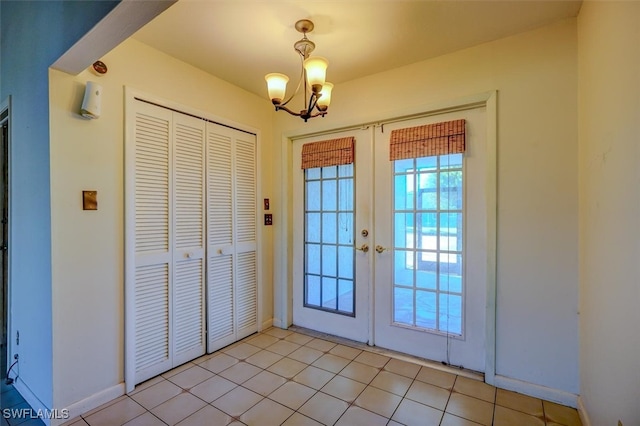 entryway featuring french doors, a notable chandelier, and light tile patterned floors