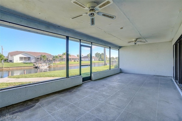 unfurnished sunroom with a water view and ceiling fan