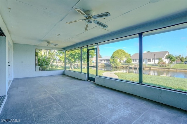 unfurnished sunroom featuring a water view and ceiling fan