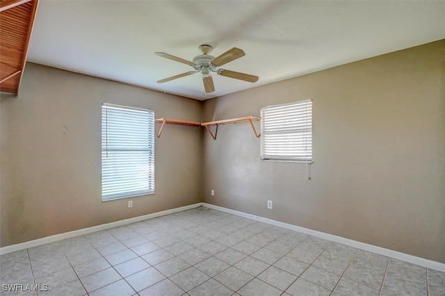 empty room featuring ceiling fan, a healthy amount of sunlight, and light tile patterned floors