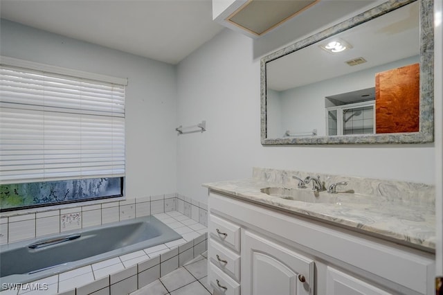 bathroom featuring vanity, tile patterned floors, and tiled tub