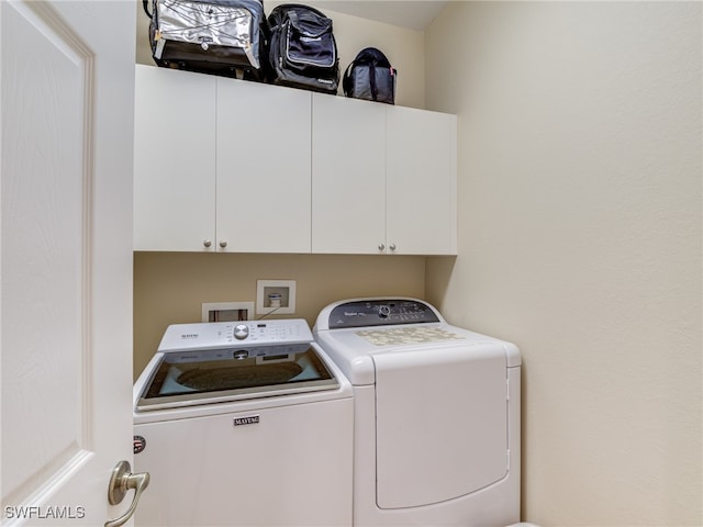 laundry area featuring cabinets and washer and clothes dryer