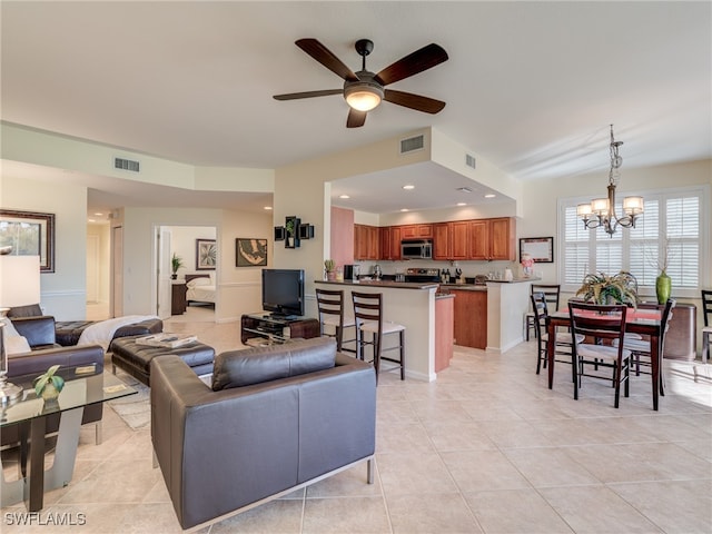 living room featuring ceiling fan with notable chandelier and light tile patterned floors