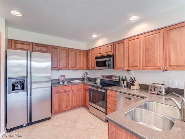 kitchen with light tile patterned flooring, stainless steel appliances, and sink